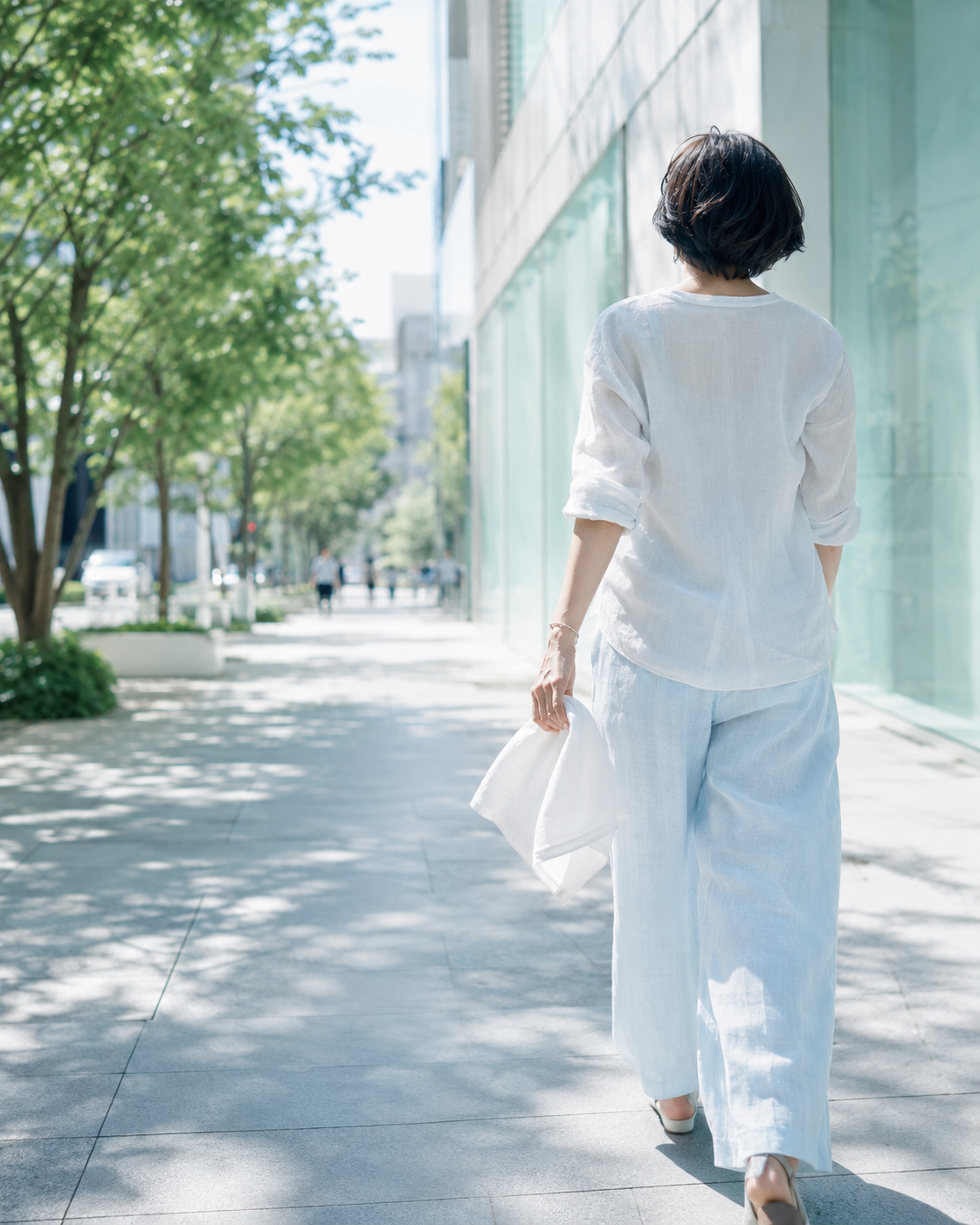 真夏の外出時にハンカチを持つ女性の後ろ姿